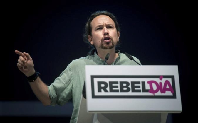 El secretario general de Podemos, Pablo Iglesias, detrás de un lema que llama a la 'rebelión' contra e sistema democrático español, durante un acto de su partido. Archivo Efe