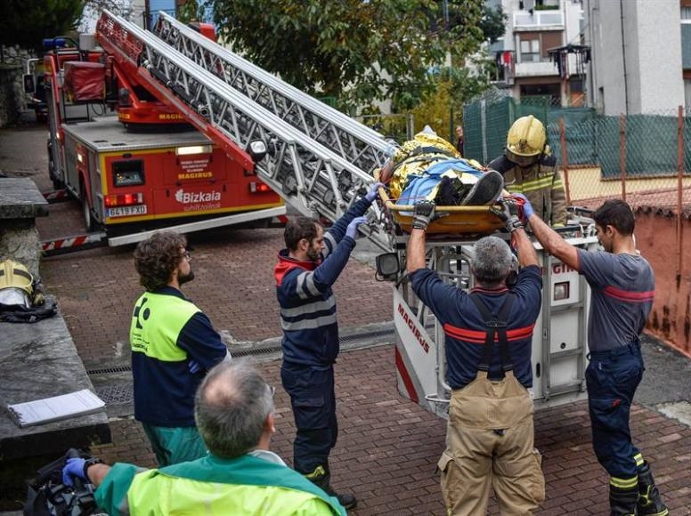 BILBAO (PAÍS VASCO) ESPAÑA, 12.11.2018. Bomberos evacuan por la fachada de su domicilio en Santurce (Vizcaya) a un hombre herido en un doble apuñalamiento. Efe.