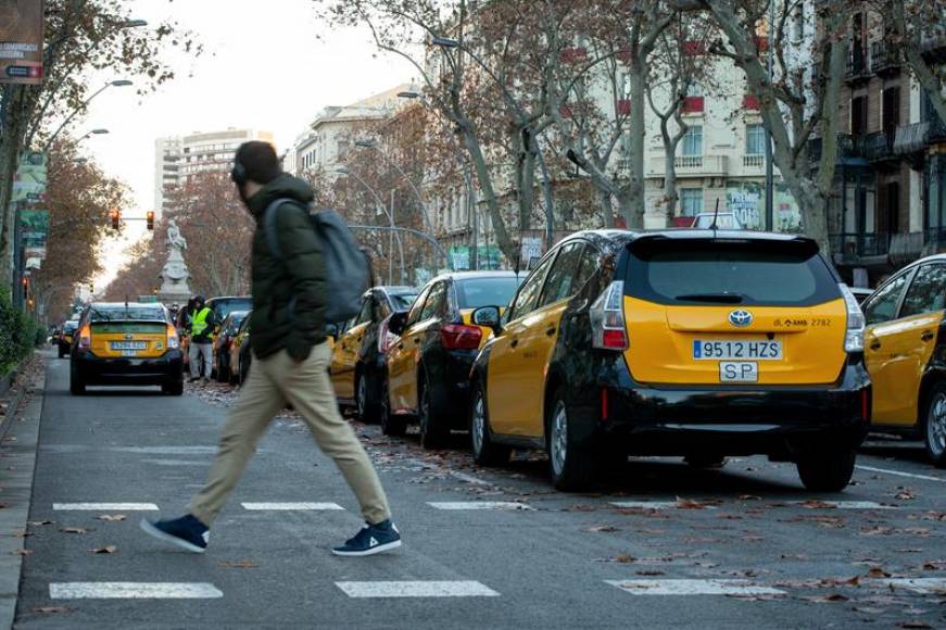 BARCELONA (ESPAÑA), 21.01.2019. Un joven cruza la Gran Vía de Barcelona donde permanecen estacionados. Efe