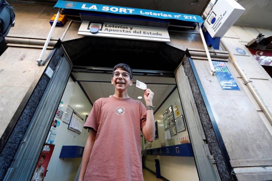 BARCELONA (ESPAÑA), 6.01.2019. Cosmin, joven que adquirió el décimo agraciado con el primer premio de la loteria del Niño, muestra su décimo con el 37.142. Efe