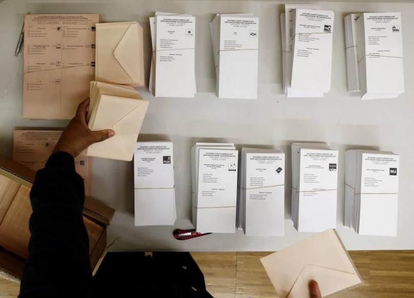 FOTOGRAFÍA. ESPAÑA, AÑO 2019. Una persona coloca en la mesa de un colegio electoral de Pamplona las papeletas con las diferentes opciones. Efe.