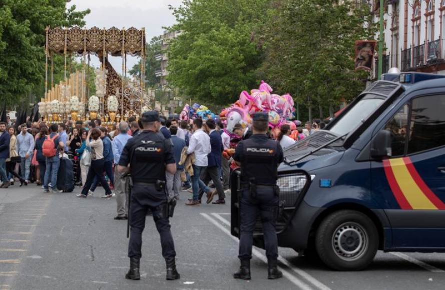 FOTOGRAFÍA. (SEVILLA) ESPAÑA, 17.04.2019. Dos agentes de la Policía Nacional vigilan el paso de Palío de la Virgen María Santísima del Refugio de la Hermandad. Efe