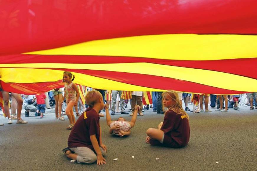 FOTOGRAFÍA. CATALUÑA (ESPAÑA), 11.09.2018. Unos niños juegan bajo una bandera separatista durante la manifestación hispanófoba del independentismo. Efe