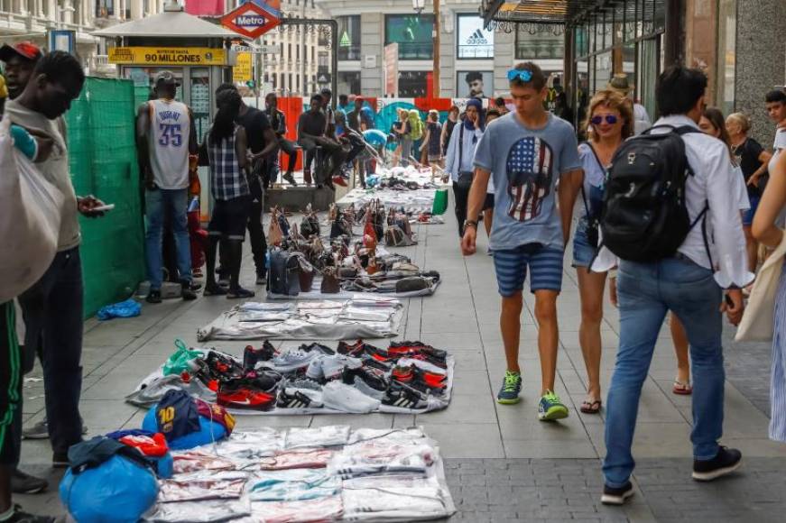 FOTOGRAFÍA. MADRID (ESPAÑA), 30.06.2019. Un grupo de manteros muestra sus productos al público que transita por la Gran Vía de Madrid. Efe.
