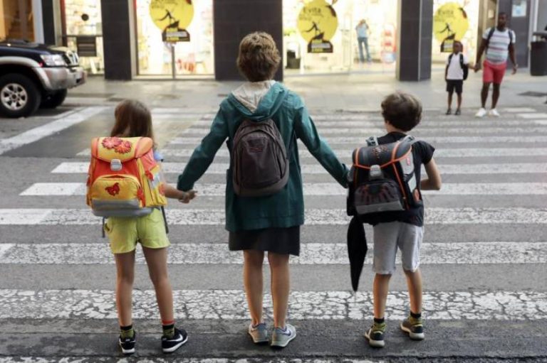 FOTOGRAFÍA. VALENCIA (ESPAÑA), AÑO 2019. na madre lleva a sus dos hijos al colegio durante el primer día de curso escolar en València. Efe.