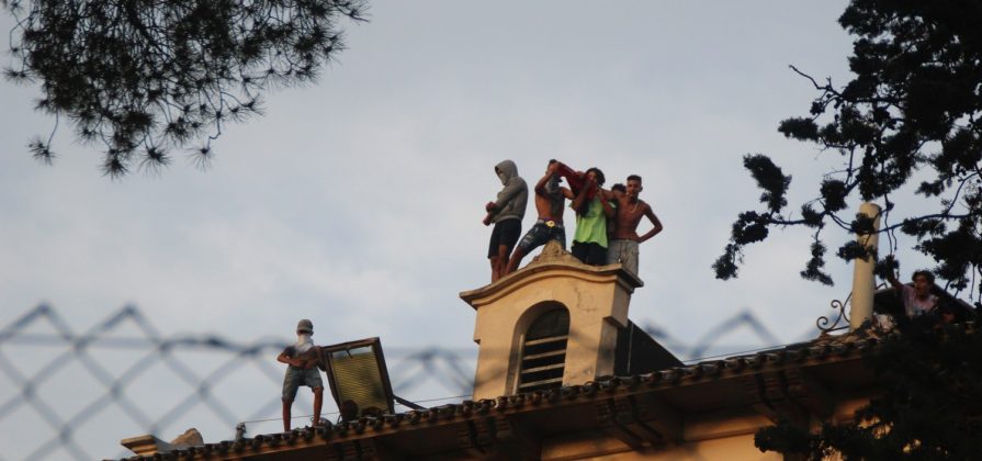 FOTOGRAFÍA. EL MASNOU (BARCELONA) ESPAÑA, 04.07.2019. Vista de un grupo de inmigrantes islamistas 'Menores no Acompañados (MENAS), unos cogiendo sus digitales y haciendo gestos obscenos mientras otros atancan con piedras a las vecinas y vecinos de la localidad española ubicada en la comarca de El Maresme (Barcelona), El Masnou, hoy desde el tejado del albergue donde están alojados por la generalidad de Cataluña y cobran '638 euros' mensuales, después del intento de agresión sexual de una joven de éste pueblo por parte de esos grupos de inmigrantes MENAS. Lasvocesdelpueblo
