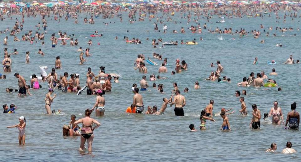 FOTOGRAFÍA. MALVARROSA (VALENCIA) ESPAÑA, 03.07.2019. Un gran número de personas se refresca en las aguas de la playa de la Malvarrosa (Valencia) en una jornada calurosa. Efe.