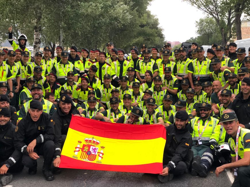 FOTOGRAFÍA. IGUALADA (BARCELONA), 31.09.2019. Los guardias civiles y Mozos de Escuadra posan juntos, detrás de la bandera de España, Vuelta Ciclista a España, Igualada, ciclista. Ñ Pueblo