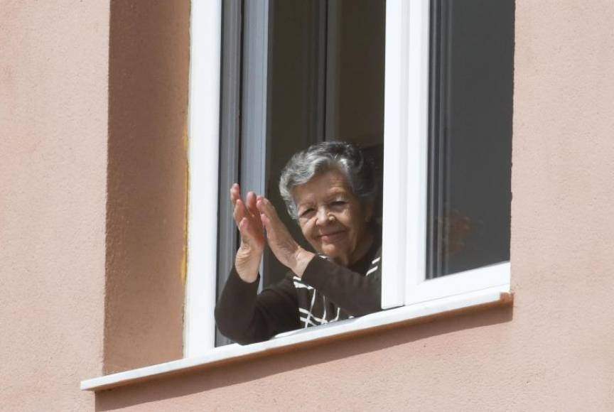 FOTOGRAFÍA. GRANADA (ESPAÑA), 27.03.2020. Una señora mayor aplaude desde una ventana de la residencia de mayores de Cájar (Granada). Efe