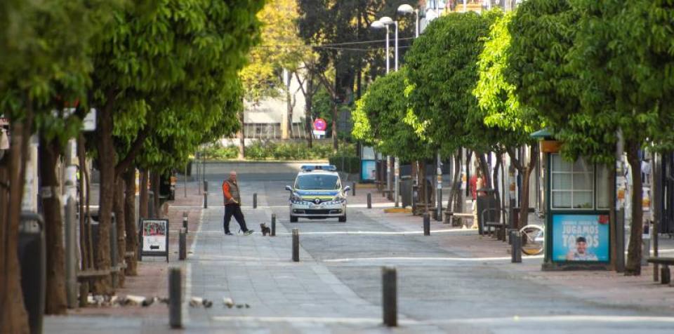 FOTOGRAFÍA. SEVILLA (ESPAÑA), 15.03.2020. Un ciudadano pasea a su perro ante la vigilancia de la policía local en la calle Asunción de Sevilla este domingo. Efe