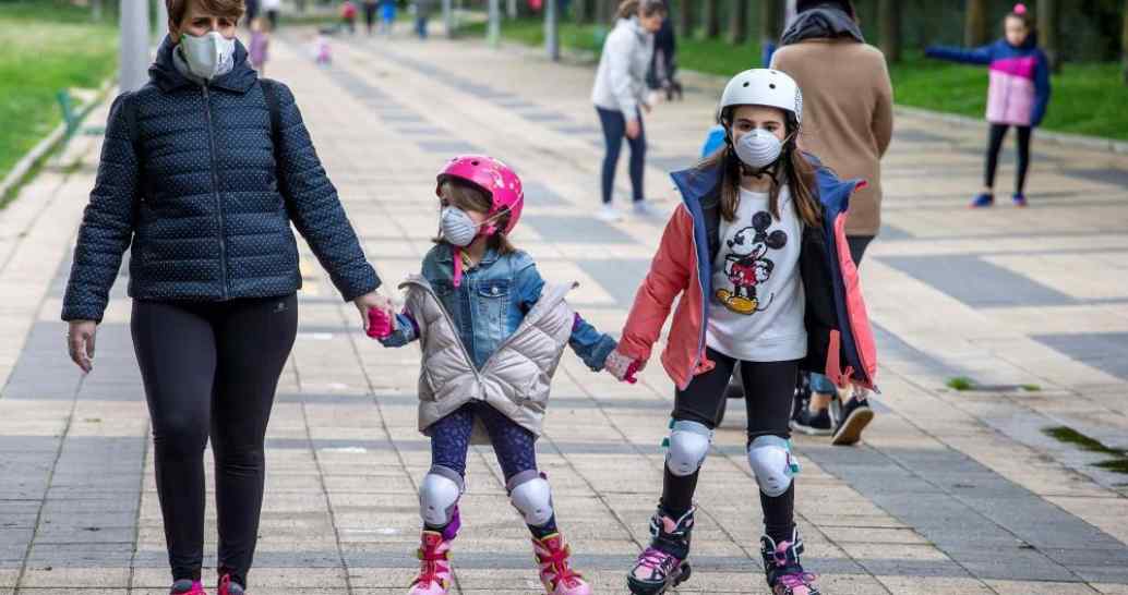FOTOGRAFÍA. ESPAÑA, 26.04.2020. Una madre y sus dos hijos menores de 14 años paseando por la calle con mascarilla durante el brote de coronavirus, tras 43 días de confinamiento. Efe