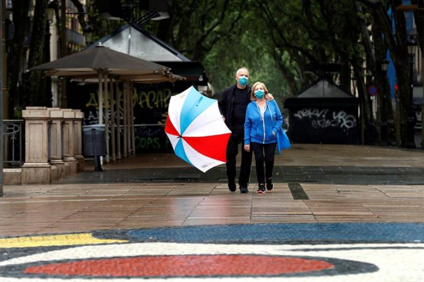 FOTOGRAFÍA. BARCELONA (ESPAÑA), 10.05.2020. Una pareja protegida con su mascarilla pasea por unas Ramblas prácticamente vacías este domingo en Barcelona. Efe