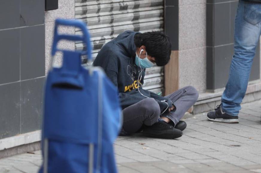 FOTOGRAFÍA. ALUCHE (MADRID CIUDAD) ESPAÑA, ABRIL DE 2020. Una persona espera en la fila para recoger alimentos proporcionados por la Asociación de vecinos de Aluche, en Madrid. Efe
