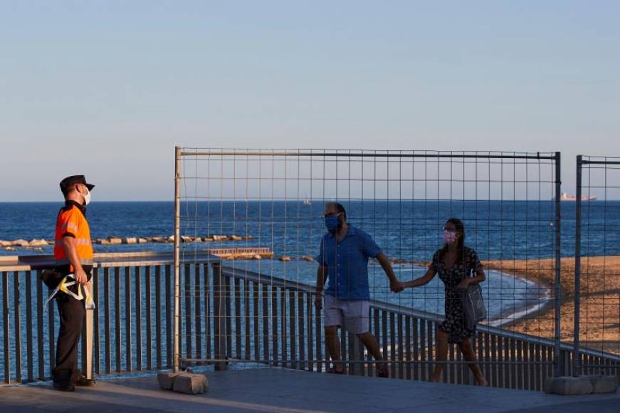 FOTOGRAFÍA. CATALUÑA (ESPAÑA), 23.06.2020. una pareja abandona una playa de Cataluña durante la verbena de San Juan 2020. Efe