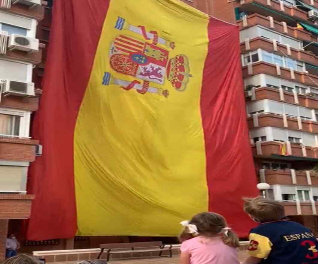 FOTOGRAFÍA. ESPAÑA, 30.05.2020. Día de las Fuerzas Armadas. Un grupo de vecinos celebra el Día de las Fuerzas Armadas izando una gigante bandera. Ñ Pueblo (1)