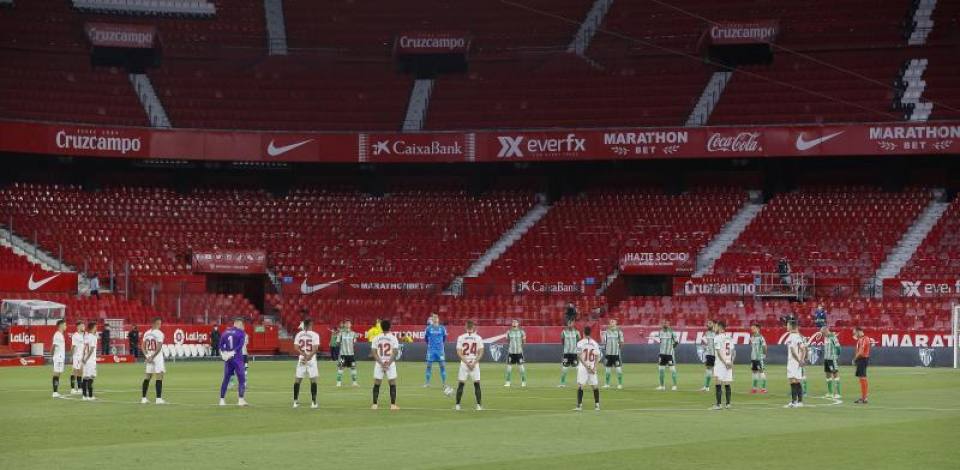 FOTOGRFAÍA. SEVILLA (ESPAÑA), 11.06.2020. Jugadores del Betis y Sevilla guardan un minuto de silencio en memoria de las víctimas del covid 19 calientan. Efe