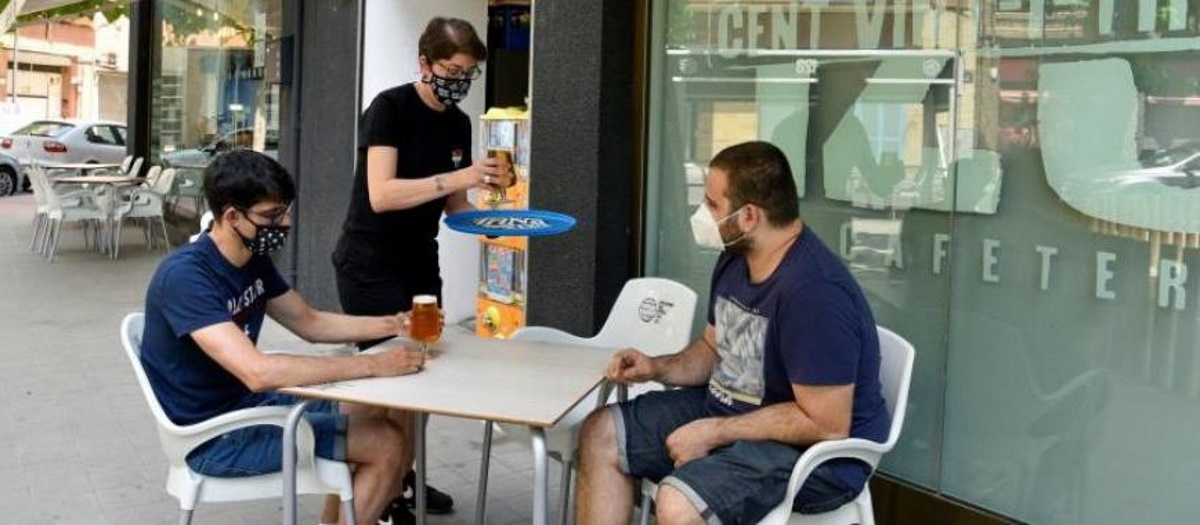 FOTOGRAFÍA. LÉRIDA (ESPAÑA), 15.07.2020. Jóvenes ataviados con mascarillas disfrutan este martes en la terraza de un bar del barrio de Cap Pont (Lérida). Efe