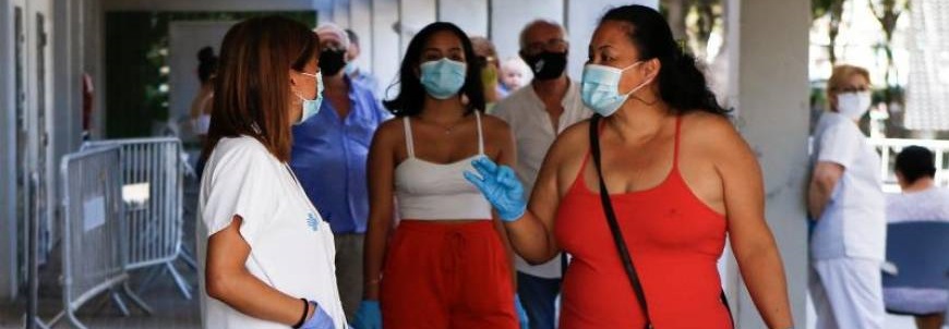 FOTOGRAFÍA. CATALUÑA (ESPAÑA), 24.08.2020. Varias personas supuestamente sanas con mascarillas hacen cola en pie en un hospital de la Comunidad autónoma de Cataluña (España). Efe