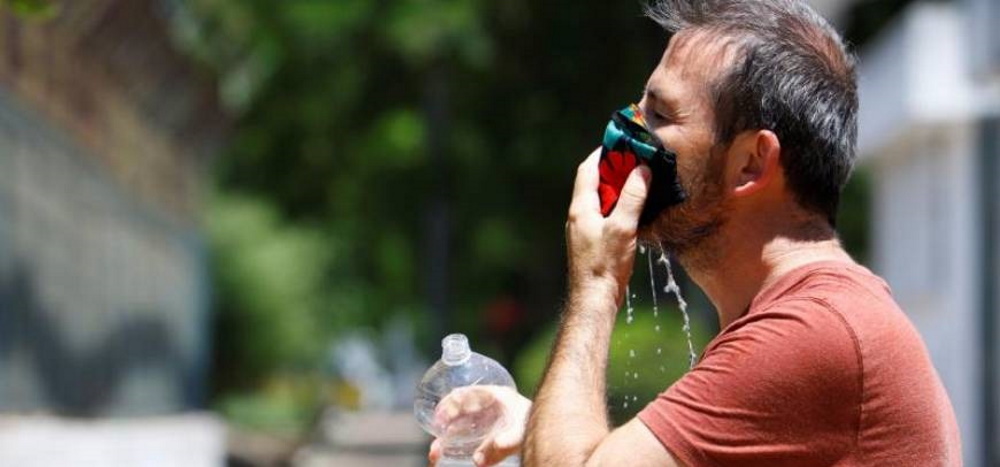 FOTOGRAFÍA. ESPAÑA, 05.08.2020. Un hombre refresca su mascarilla ante las altas temperaturas. Efe