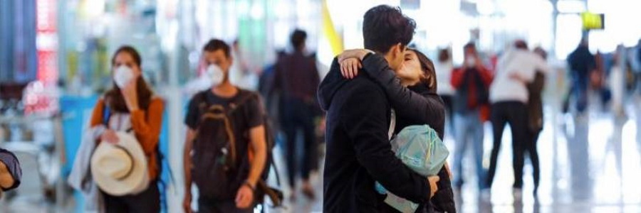 FOTOGRAFÍA. MADRID (ESPAÑA), AGOSTO 2020. Una pareja se besa en el aeropuerto Madrid-Barajas Adolfo Suárez, junto a otros viajeros protegidos con mascarillas. Efe
