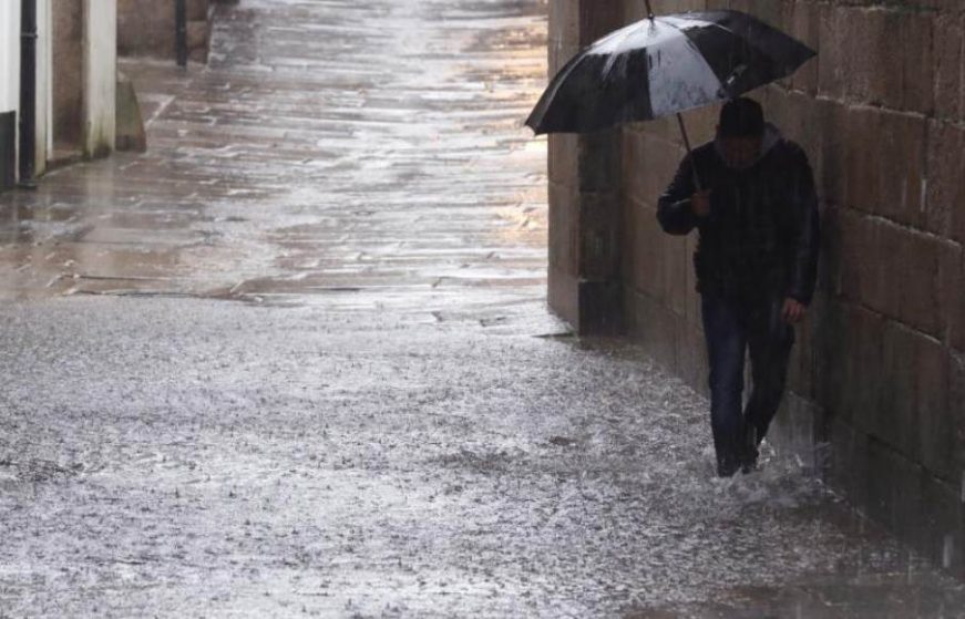 FOTOGRAFÍA. SANTIAGO DE COMPOSTELA (ESPAÑA), AÑO 2020. Un hombre se cubre de la lluvia con un paraguas mientras pasea por una calle de Santiago de Compostela (España). Efe
