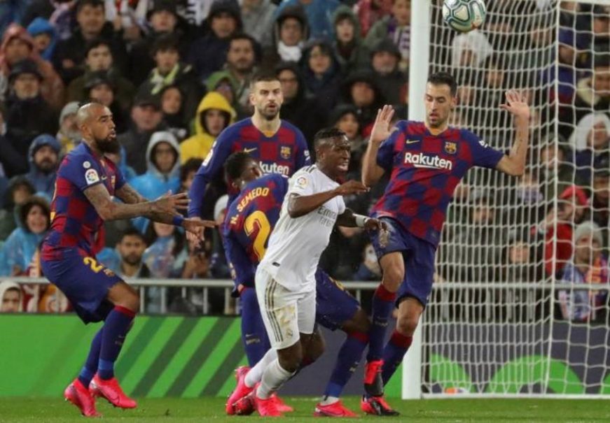 FOTOGRAFÍA. SANTIAGO BERNABÉU (ESTADIO DEL REAL MADRID) MADRID (ESPAÑA), 01.03.2021. El delantero del Real Madrid Vinicius Jr. (c) cae junto a los jugadores del FC Barcelon. Efe