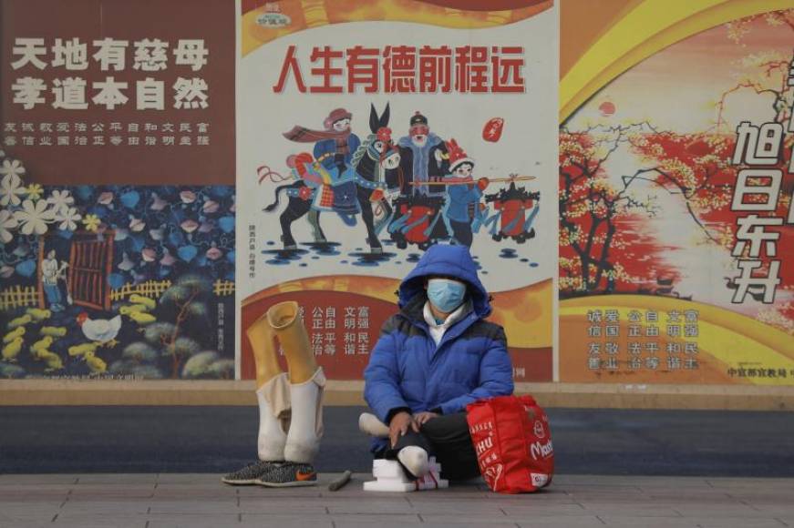 FOTOGRAFÍA. BEIJING (CHINA), 11.02.2020. A disabled passenger wearing protective mask rests beside her artificial limbs at Beijing railway station in Beijing, China. Efe