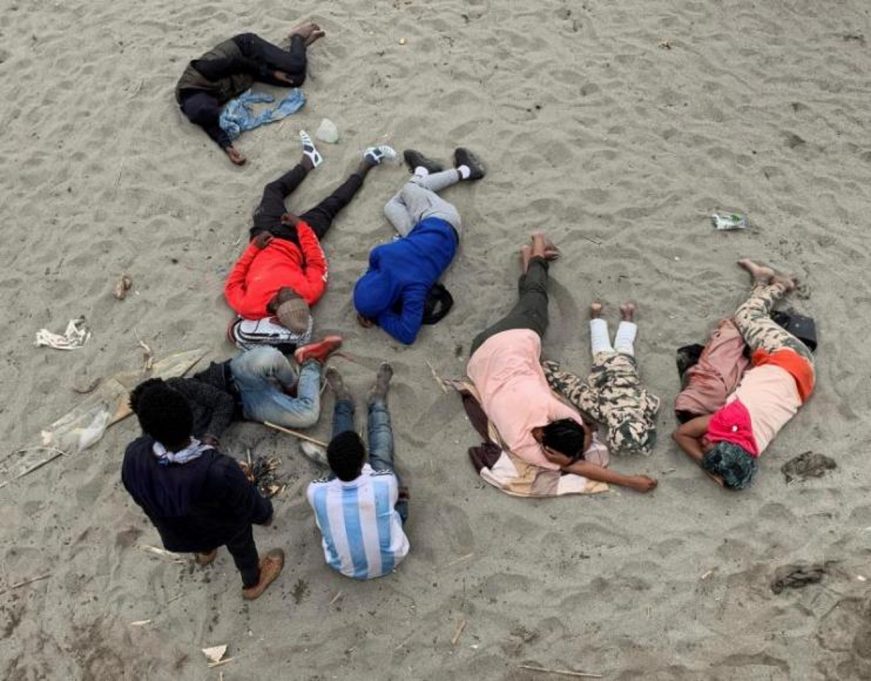 FOTOGRAFÍA. FNIDEQ (MARRUECOS), 18.05.2021. Un grupo de inmigrantes ilegales marroquíes descansa en la playa de la localidad de Fnideq (Castillejos). Efe