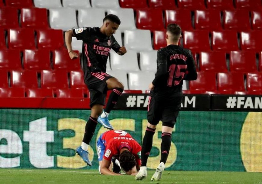 FOTOGRAFÍA. GRANADA (ESPAÑA), 13.05.2021. Los jugadores del Real Madrid, el brasileño Rodrigo (i) y el uruguayo Valverde, celebran ante el defensa del Granada. Efe