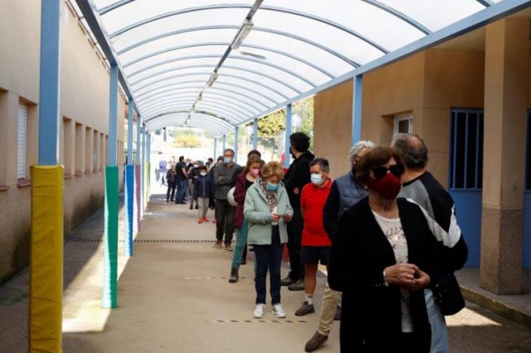Las largas colas de la mañana en muchos colegios del 4M de Madrid para votar se repiten por la tarde