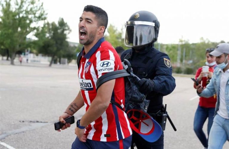 El delantero del Atlético Luis Suárez es reducido por un policía tras celebrar con la afición el título de la liga
