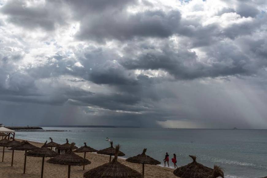 FOTOGRAFÍA. PALMA DE MALLORCA (ESPAÑA), 01.06.2021. Una pareja camina bajo la lluvia en la Playa de Can Pere Antoni , en Palma de Mallorca. Efe