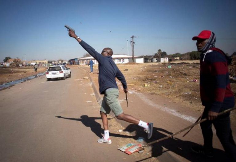 FOTOGRAFÍA. JOHANNESBURGO (SUDÁFRICA), 15.07.2021. Un taxista dispara al aire con su pistola 9mm para ahuyentar a los saqueadores en un área comercial de Johannesburgo. Efe