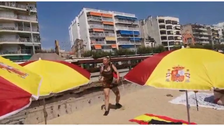 Una separatista enloquecida ataca una sombrilla española y amenaza de muerte a los catalanes en Blanes (Gerona)