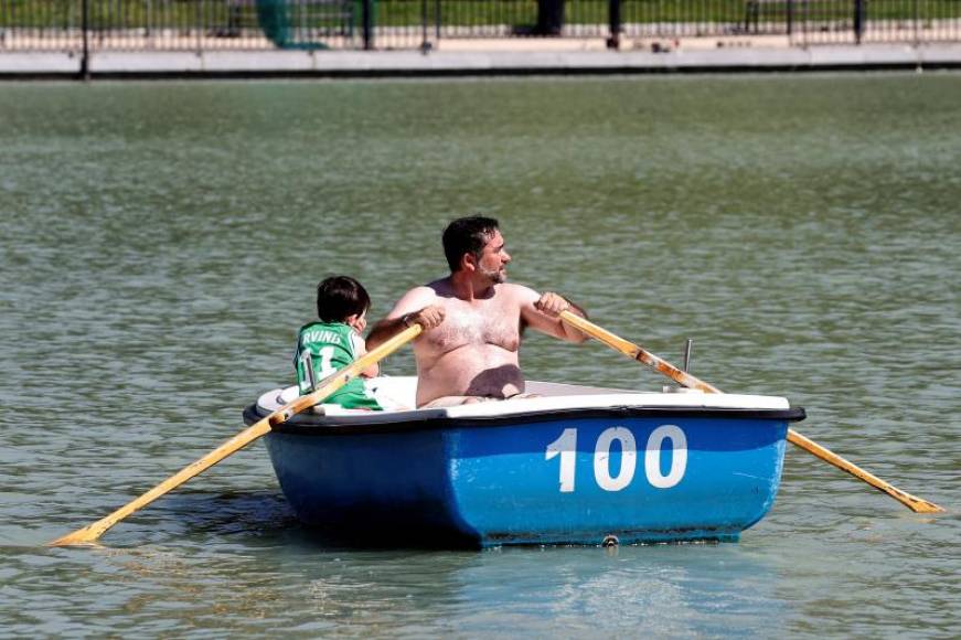 FOTOGRAFÍA. MADRID (ESPAÑA), 19.08.2021. Un hombre y un niño disfrutan de un paseo en barca en el lago del Parque del Retiro de Madrid. Efe