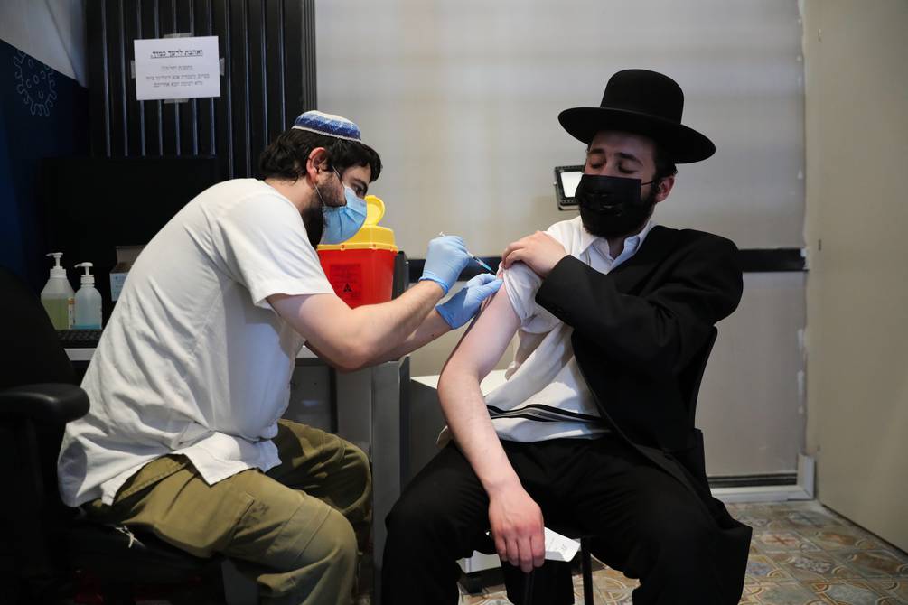 FOTOGRAFÍA. JERUSALÉN (ISRAEL), 03.09.2201. Un sanitario inyecta el experimento genético de las empresas farmacéuticas (vacuna covid 19). Efe