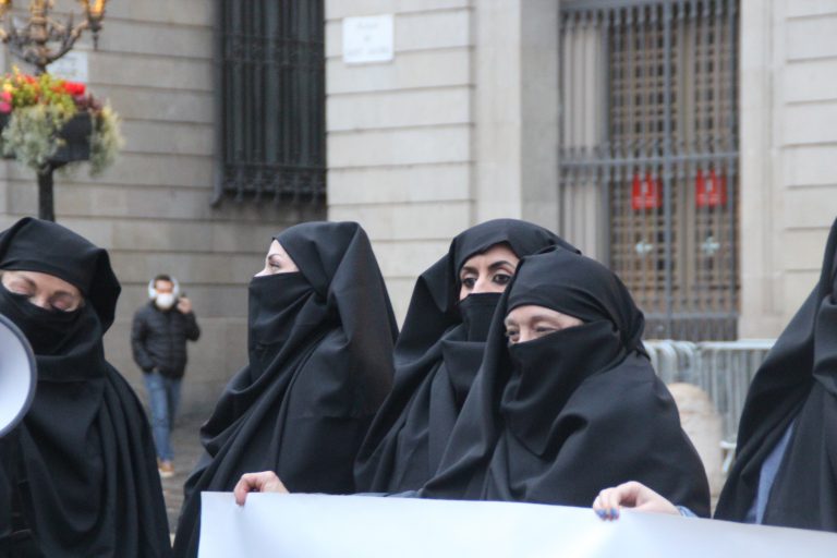 FOTOGRAFÍA. BARCELONA (ESPAÑA), 08.03.2022. Mujeres por la Igualdad protestan contra el «burka ideológico impuesto por el feminismo supremacista a las españolas» este martes en Plaza San Jaime de Barcelona con el motivo del Día Internacional de la Mujer Trabajadora, una iniciativa de la Asociación Mujeres por la Igualdad (AMPI). Lasvocesdelpueblo (Ñ Pueblo)