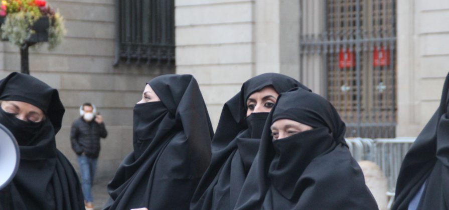FOTOGRAFÍA. BARCELONA (ESPAÑA), 08.03.2022. Mujeres por la Igualdad protestan contra el «burka ideológico impuesto por el feminismo supremacista a las españolas» este martes en Plaza San Jaime de Barcelona con el motivo del Día Internacional de la Mujer Trabajadora, una iniciativa de la Asociación Mujeres por la Igualdad (AMPI). Lasvocesdelpueblo (Ñ Pueblo)