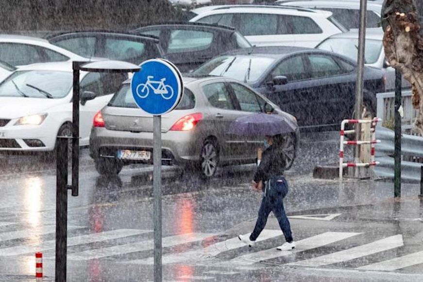 FOTOGRAFÍA. MURCIA (ESPAÑA), 16.03.2022. Una mujer cruza un paso de peatones bajo una intensa tormenta en Murcia. Efe
