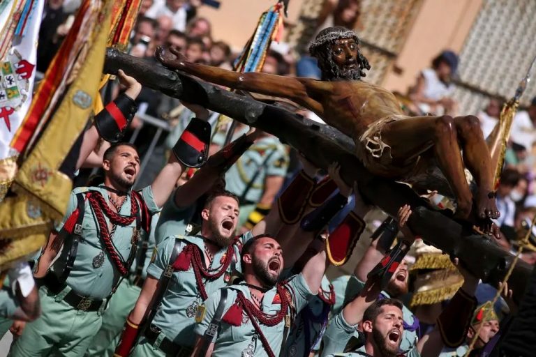 FOTOGRAFÍA. MÁLAGA (ESPAÑA), JUEVES SANTO (SEMANA SANTA 2022), 14.04.2022. Procesiones de Melilla con militares. Una multitud asiste al traslado del Cristo de la Buena Muerte y Ánimas, por parte de legionarios del Tercio Gran Capitán, a la casa hermandad de la Cofradía de Mena este Jueves Santo en Málaga con Nuestra Señora de la Soledad Coronada. Efe