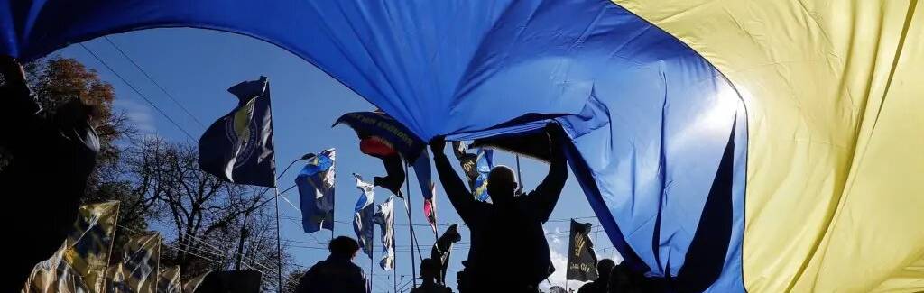 FOTOGRAFÍA. KIEV (UCRANIA), OCTUBRE DE 2022. Un grupo de personas ondeando una bandera nacional ucraniana gigante en el centro de Kiev. Efe