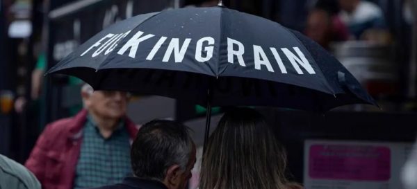 FOTOGRAFÍA. OVIEDO (ASTURIAS) ESPAÑA, 24.10.2022. Una pareja se protege de la lluvia con un paraguas que dice Puta Lluvia, en inglés «fucking Rain», en una calle del centro de Oviedo (Asturias) España. Lluvia, precipitaciones, mal tiempo, agua, rain, fucking Rain, puta lluvia, tormenta. Efe
