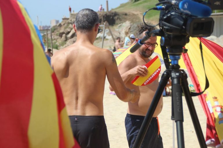 FOTOGRAFÍA. PLAYA DE MONTGAT (BARCELONA), 04.08.2019. Lluvias y tormentas o vientos en España. Los catalanes continúan con sus llamada revolución veraniega de las sombrillas' con una parada en la playa de la localidad española de Montgat. Temperaturas, lluvias, primavera, verano, España, tiempo, bandera, precipitaciones. Lasvocesdelpueblo
