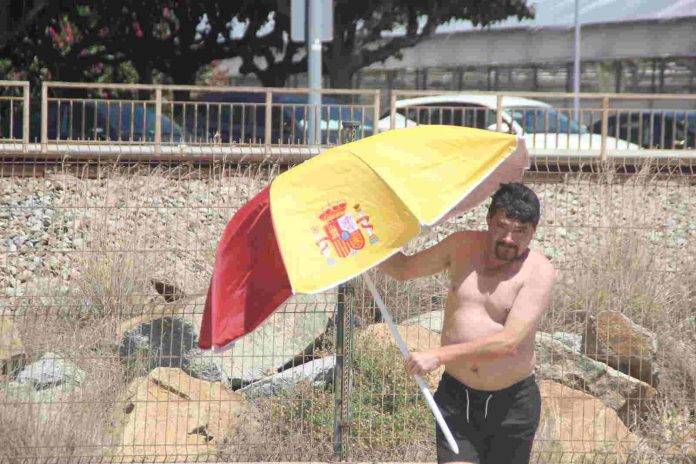 FOTOGRAFÍA. PREMIA DE MAR (BARCELONA) ESPAÑA, 05 DE AGOSTO DE 2023. Aumentos de temperaturas máximas en la mitad norte de España. Varios vecinos catalanes participan en una plantada de sombrillas de colores y simbolos institucionales del Reino de España en la playa de Premia de Mar (barcelona), formando la letra «Ñ» y dejando un claro mensaje al nuevo Gobierno de España que previsiblemente necesitará los síes del partido del prófugo d ela Justicia y golpista Carles Puigdemont Casamajò, Juntos por Cataluña (JxCat). Temperaturas. Lasvocesdelpueblo (Ñ Pueblo)