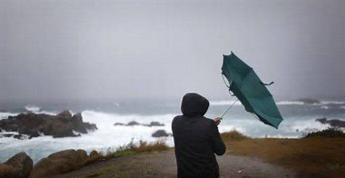 FOTOGRAFÍA. LA CORUÑA (GALICIA) REINO DE ESPAÑA, 03 DE ENERO DE 2016. Cielos nubosos y calima en España. Detalle de una persona que ve cómo el viento le dobla el paraguas en La Coruña, comunidad autónoma de Galicia, en el Reino de España. Efe