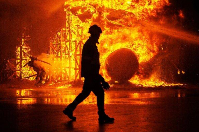 FOTOGRAFÍA. VALENCIA (REINO DE ESPAÑA), 19 DE MARZO DE 2024. Un bombero pasa ante una falla consumida por el fuego durante la cremà. Mucha amnistía criminal, mucha tensión. Este año, los cientos de miles de personas que han paseado por València han comprobado cómo la corrupta amnistía y el "procés" del separatismo catalán dominaba el argumentario satírico de las fallas, con prófugo Carles Puigdemont y Pedro Sánchez como protagonistas del relato fallero con permiso de las guerras y el anhelo de paz, con un omnipresente Putin, así como el medio ambiente y sus crisis, la economía y sus altibajos, la farándula televisiva y sus bambalinas y las redes sociales y sus esclavitudes. Nada de eso queda ya. Un dispositivo de 380 bomberos municipales controlan hasta las tres de la madrugada la Cremà de un centenar de fallas para que no haya ningún problema, especialmente después de que cuatro comisiones hayan pedido cambiar la ubicación de su monumento o de la zona de fuegos ante su cercanía a edificios con fachadas ventiladas, como la que tenía el bloque residencial incendiado de Campanar. Efe