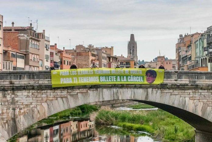 Billete de cárcel para Puigdemont y de vuelta para ilegales (2) FOTOGRAFÍA. GERONA (REINO DE ESPAÑA), 25 DE ABRIL DE 2024. - VOX ofrece billete de cárcel para Puigdemont y de vuelta para ilegales. Varios afiliados y simpatizantes de Vox en la provincia de Gerona (Cataluña) cuelgan una pancarta gigante con el lema: "Para los ilegales tenemos billete de vuelta". "Par ti billete de cárcel" con foto de Puigdemont. La formación concurre al 12M catalán por Gerona al Parlament de Catalunya con el candidato Alberto Tarradas Peneque. Lasvocesdelpueblo (Ñ Pueblo)