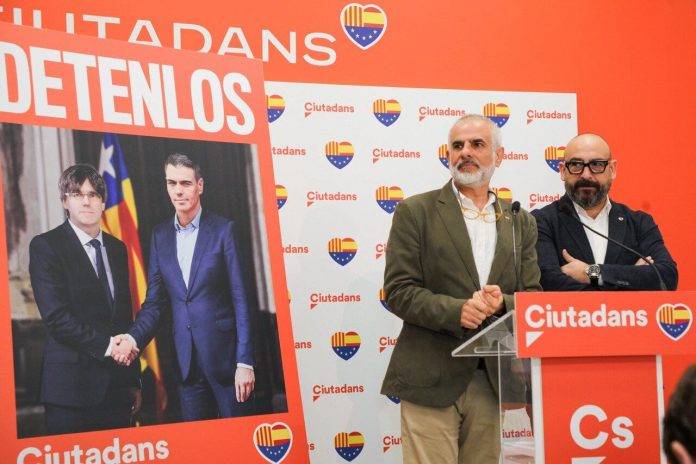 FOTOGRAFÍA. BARCELONA (REINO DE ESPAÑA), 08 DE ABRIL DE 2024. Cs exige detener a Puigdemont y Sánchez en su cartel del 12M. Cartel electoral Cs "Detenlos" deja ver en él se ve, en primer plano, una "visita de Estado" de un "presidente español, Pedro Sánchez Pérez-Castejón (fondo dcha), a un presidente de una Cataluña independiente, Carles Puigdemont Casamajó (fondo izd), con una bandera separatista, la "estelada", de fondo.; una iniciativa presentada por el eurodiputado, jefe de campaña del 12M y portavoz nacional de este partido, Jordi Cañas Pérez (d), y por el candidato de la formación naranja a la Presidència del Govern de la Generalitat de Catalunya, Carlos Carrizosa Torres (i), este lunes en Barcelona. Lasvocesdelpueblo (Ñ Pueblo)