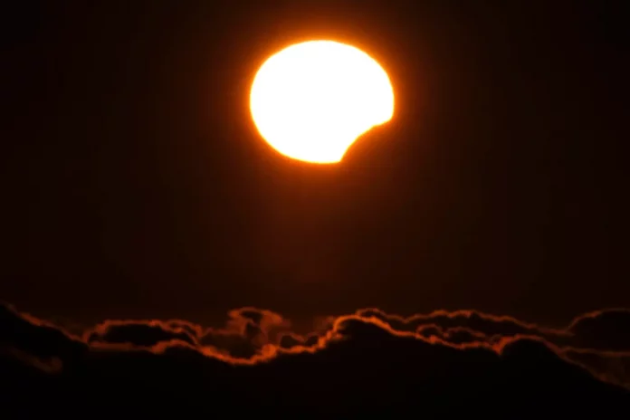 FOTOGRAFÍA. FERROL (LA CORUÑA) GALICIA (REINO DE ESPAÑA), 08 DE ABRIL DE 2024. Jornada de calor y sol en España. La Luna oculta la parte inferior del Sol, durante el eclipse parcial visto este lunes en la costa de Ferrol, en A Coruña. El eclipse sobre el mar de nubes fotografiado desde el exterior del Observatorio Astronómico del Teide, en Izaña (Tenerife), a 2.364 metros de altitud. Un pequeño grupo de personas ha disfrutado en el ocaso de este lunes del eclipse solar parcial desde el observatorio del Teide, en Izaña (Tenerife), donde fueron testigos privilegiados de un fenómeno que solo ha sido visible en España desde las islas más occidentales de Canarias, porque en Galicia las nubes arruinaron el momento. Para lograr su objetivo, los asistentes a este espectáculo de la naturaleza, en su mayoría vinculados al Instituto de Astrofísica de Canarias (IAC), han sorteado la lluvia y el viento a través de la sinuosa carretera que avanza desde la costa hacia la base del volcán, atravesando el tupido mar de nubes que envuelve la isla. Efe