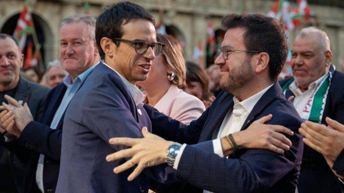 FOTOGRAFÍA. BILBAO (VIZCAYA) LAS VASCONGADAS (REINO DE ESPAÑA), 19 DE ABRIL DE 2024. Aragonès arropa al socio de ERC ETA (Bildu) en cierre 21A. La banda terrorista separatista y comunista ETA (EH Bildu) ha cerrado la campaña electoral con un mitin en Bilbao en el que ha tenido como "invitados" al candidato de ERC a president del Govern de la Generalitat de Catalunya y coordinador general de la extrema izquierda secesionista ERC, Pere Aragonès García (d), entre los brazos de sus compinche candidato de ETA (EH Bildu) al 21A, Pello Otxandiano Kanpo (i). Además, ETA (EH Bildu), como no podría ser de otra manera, ha recibido los apoyos de los grupos terroristas internacionales de la extrema izquierda, de la mano del ministro de finanzas de Irlanda del Norte, Conor Murphy por el Sinn Fein -reconocido por la Universidad de London (Reino Unido) como "brazo político de un grupo terrorista"-, y se han proyectado vídeos de apoyo de la prófuga de la Justicia española, secretaria general de ERC, cabecilla de la célula terrorista del Procés: Plataforma Tsunami Democràtic, en la los investigadores del caso pudieron identificarla con el nombre "Matagalls" (Matagallos), Marta Rovira Vergés; el terrorista y comunista -exguerrillero quien fue el 40.º presidente de Uruguay entre 2010 hasta 2015, con pasado como miembro del grupo terrorista de extrema izquierda uruguayo, ​"Movimiento de Liberación Nacional-Tupamaros", José Alberto Mujica Cordano (Pepe Mujica); y la ultraizquierdista separatista, vicepresidenta del partido Sinn Féin desde febrero de 2018 y actual primera ministra de Irlanda del Norte, Michelle O'Neill. Efe